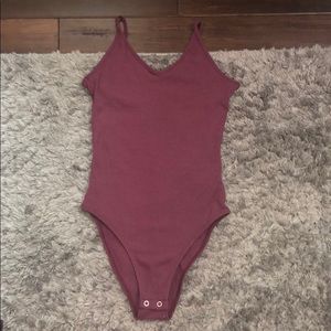 A dark red body suit